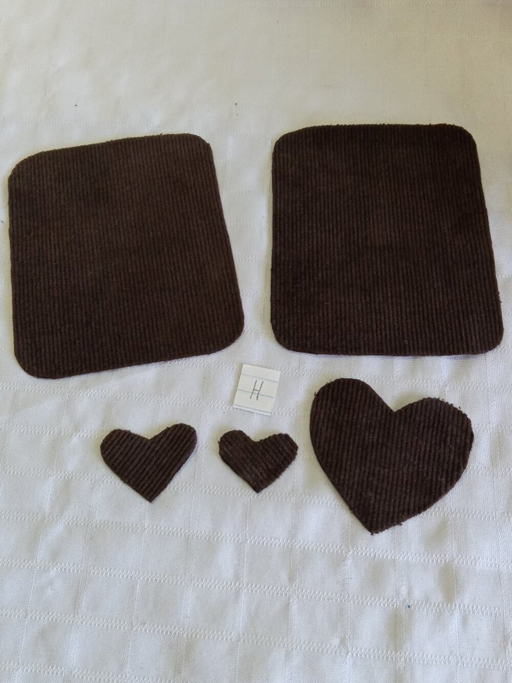 Two handmade elbow patches for sewing made of brown corduroy with hearts